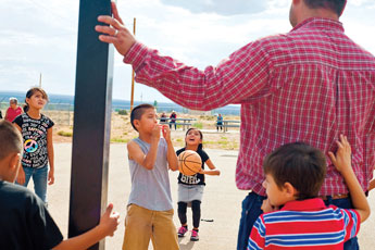 Shalayne Saunders, center, takes aim in a basketball shootout during the Fourth of July family carnival at the Thoreau Community Center Monday. © 2011 Gallup Independent / Cable Hoover